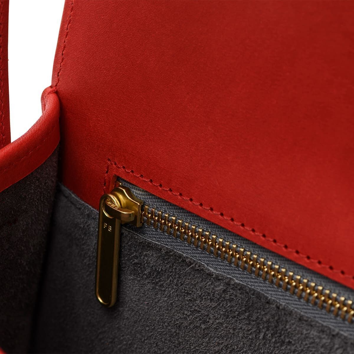 Nahaufnahme einer roten Lederschultertasche der Sonderedition »DIE ZEIT 5« mit Goldreißverschluss und grauem Innenfutter.