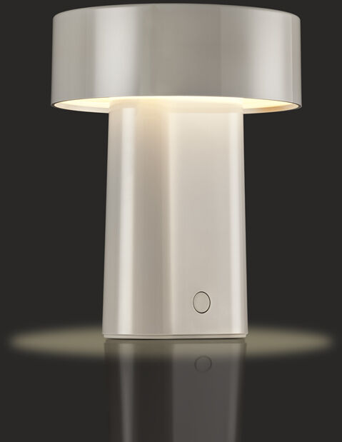 Auf dem Bild ist eine moderne, tragbare Tischlampe mit weißem, minimalistischem Design auf dunklem Hintergrund zu sehen. Die Lampe hat einen breiten, runden Schirm und ein rechteckiges Gehäuse. Das warmweiße Licht schafft eine gemütliche Atmosphäre. Die Lampe ist eingeschaltet und wirft einen sanften Lichtschein auf den Untergrund.