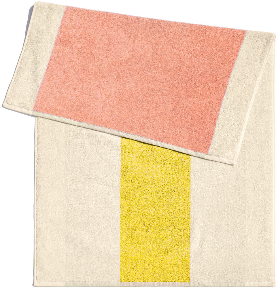 Badematte in den Abmessungen 50 x 80 cm mit großem gelbem Streifen in der Mitte und altrosafarbenem Streifen an einer Seite, auf beigem Hintergrund.