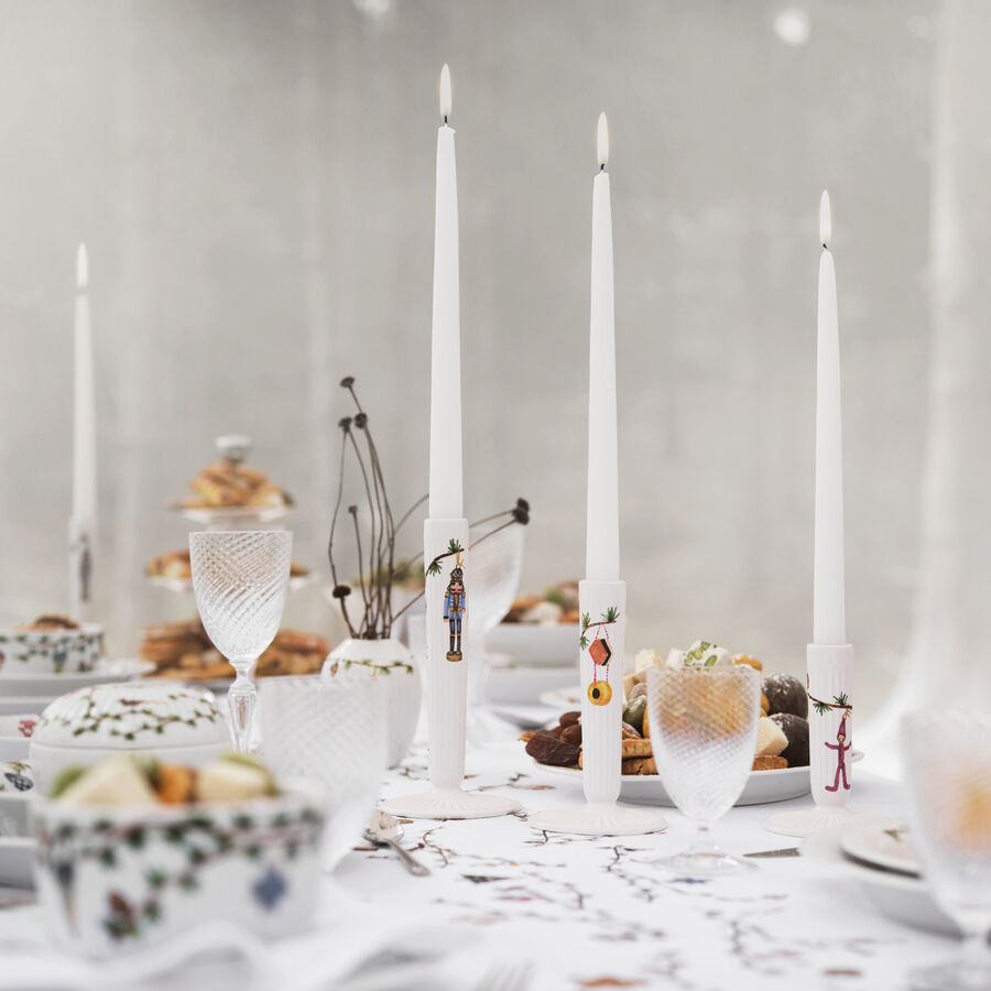 Ein elegant gedeckter Tisch mit verschiedenen weißen Kerzenständern aus der Hammershøi-Kollektion und brennenden weißen Kerzen darauf. Umgeben von feinem Porzellangeschirr mit floralen Mustern, Gläsern und Gebäck.