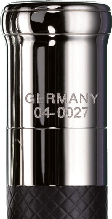 Eine Nahaufnahme des ZEIT Sonderedition »Design 04« Kugelschreibers. Der Kugelschreiber hat eine glänzende silberfarbene Metallkappe und ein schwarz-gemustertes Griffstück. Auf der Kappe ist 'GERMANY 04-0027' eingeprägt.