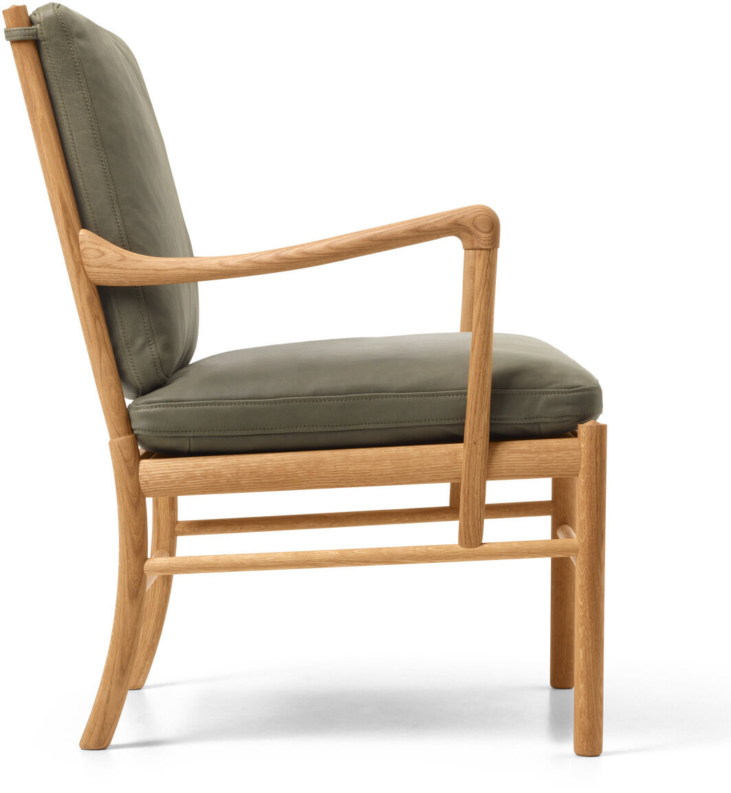 Seitliche Ansicht eines eleganten Sessels mit naturbelassenem Holzrahmen und dunkelgrünem Lederpolster, geeignet für Wohnzimmer oder exklusive Innenausstattungen.