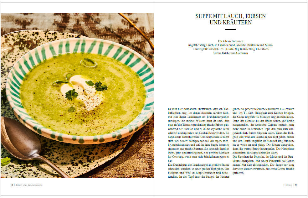 Aufgeschlagene Buchseiten zeigen ein Rezept für eine Suppe mit Lauch, Erbsen und Kräutern. Die Suppe ist grün und wird in einer gefleckten Schüssel serviert, neben dem Rezepttext und einem ansprechenden Foto der zubereiteten Suppe.