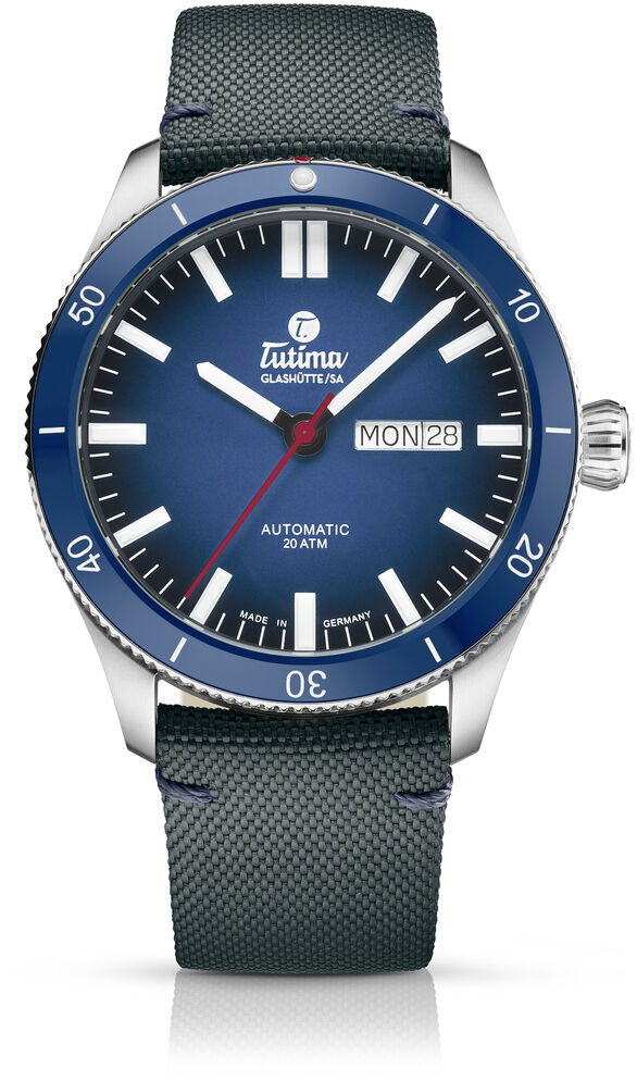 Die ZEIT-Sonderedition »Grand Flieger Airport Automatic« ist eine Herrenarmbanduhr mit einem blauen Zifferblatt, einem schwarzen Lederarmband und einem Edelstahlgehäuse. Sie verfügt über eine Datumsanzeige und ist stilvoll und exklusiv im Design.