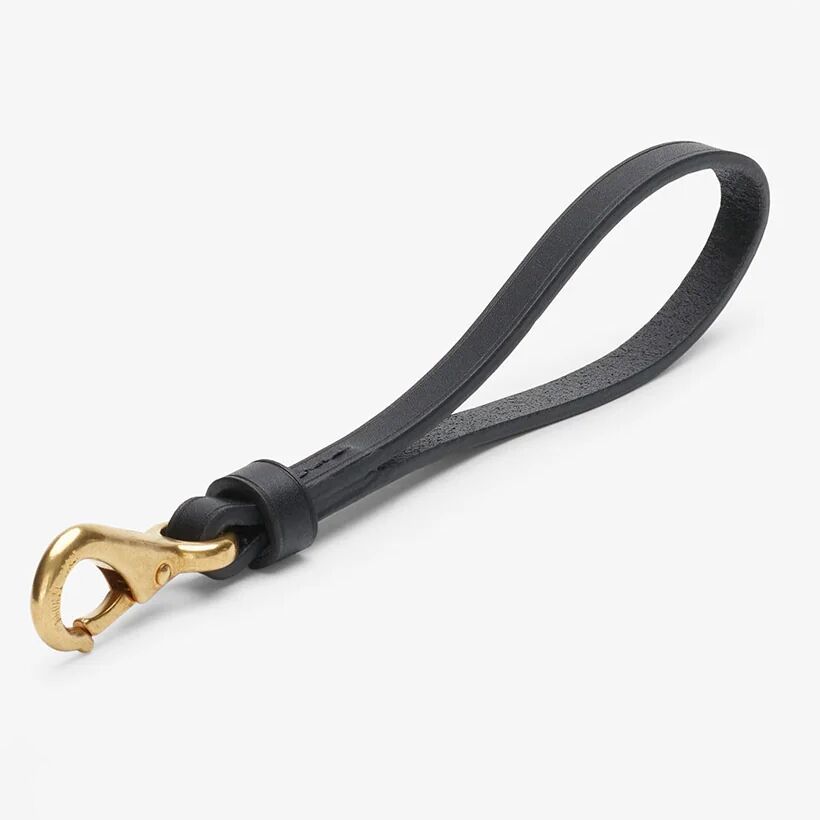 Langer Schlüsselanhänger aus hochwertigem schwarzem, pflanzlich gegerbtem Rindleder von MISMO. Die Kanten sind sauber poliert, das Leder ist vollnarbig und robust. An einem Ende befindet sich ein massiver, goldfarbener, lackgeschützter Karabinerhaken mit eleganter Prägung.