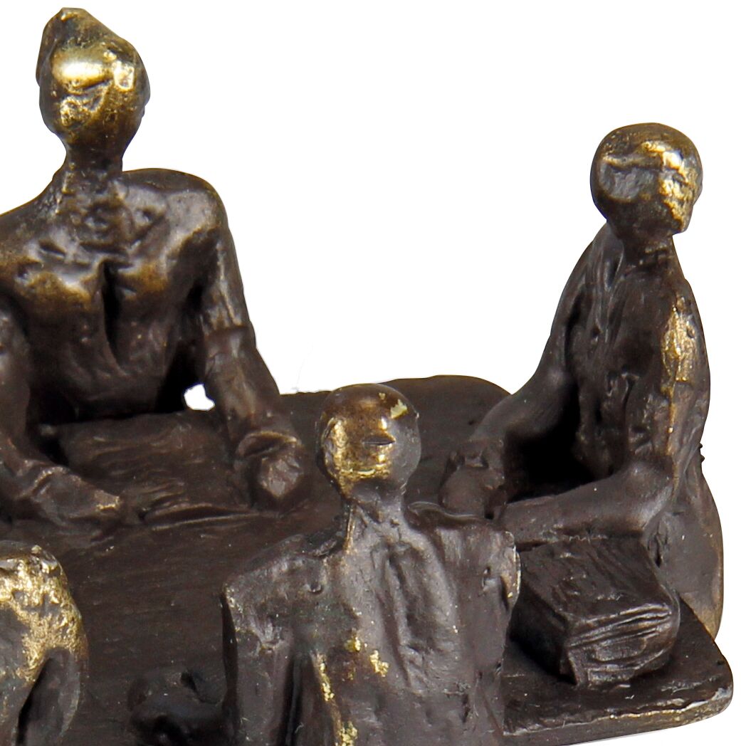 Detailreiche Metallskulptur: Vier abstrahierte, menschliche Figuren sitzen um einen eckigen Tisch. Die Statue wirkt massiv, mit glatten und glänzenden Oberflächen in Bronze- und Goldtönen. Alle Personen erscheinen in einer Besprechung vertieft. Die Szene vermittelt eine professionelle, geschäftliche Atmosphäre.