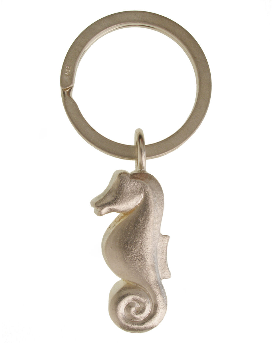 Ein silberner Schlüsselanhänger mit einem Seepferdchen-Anhänger. Der Anhänger ist aus Metall gefertigt und hat eine glatte, glänzende Oberfläche. Das Seepferdchen-Design ist detailliert und dekorativ, perfekt als Accessoire für Schlüssel oder Taschen.
