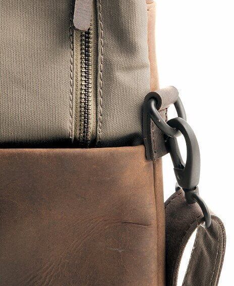 Nahaufnahme eines Rucksacks »Twister«, der aus braunem Leder und grauem Canvas besteht. Zu sehen ist ein Reißverschluss und ein Griff.
