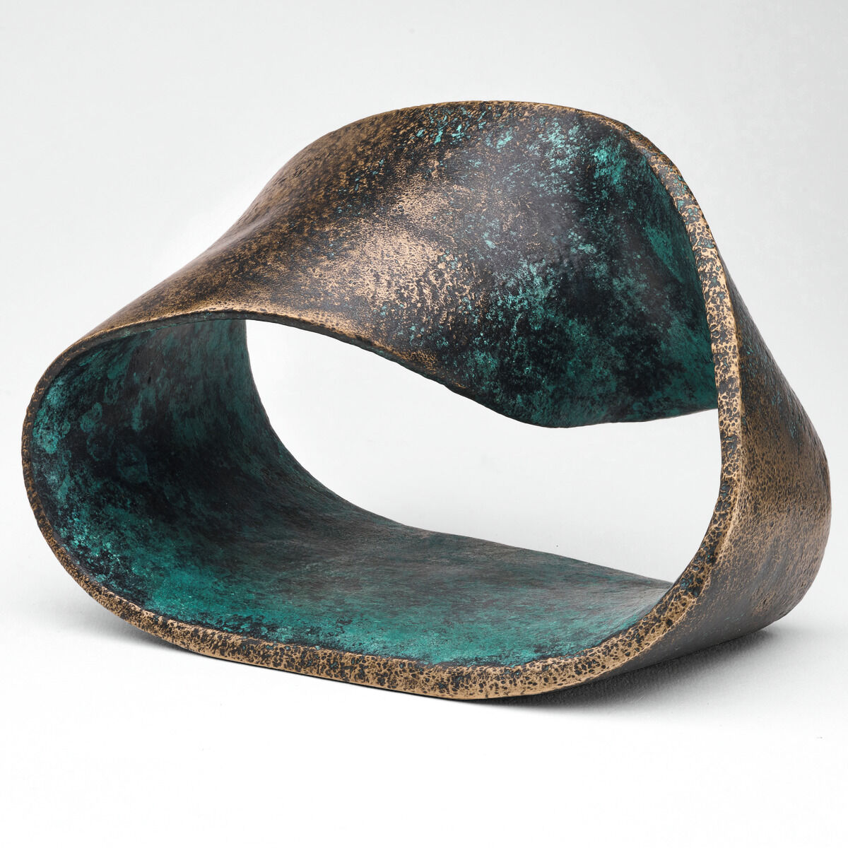 Die detailreiche Skulptur 'Möbiusband' von Pierre-Paul Maillé, gefertigt aus dunkler Bronze, zeigt ein elegant verschlungenes Band mit nahtloser, sanft glänzender Oberfläche auf einem schlichten Sockel. Der abstrakte Charakter und die tiefen Lichtreflexe verleihen dem Kunstwerk einen modernen, hochwertigen Eindruck.