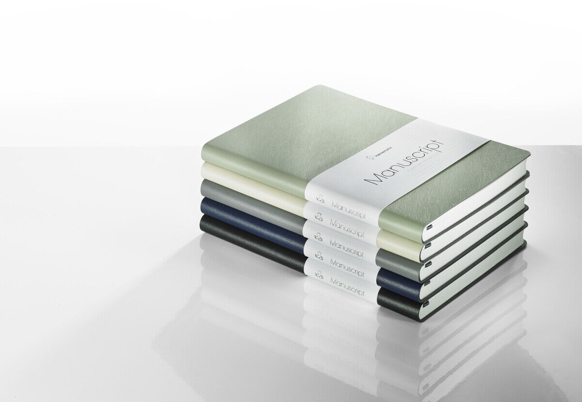 Ein Stapel von sechs Notizbüchern »Manuscript« im Format DIN A5. Jede der Notizbücher hat ein minimalistisches Design in verschiedenen Farben: Grün, Weiß, Blau und Schwarz. Die Bücher sind mit einem weißen Papierband verschnürt, auf dem 'Manuscript' steht.
