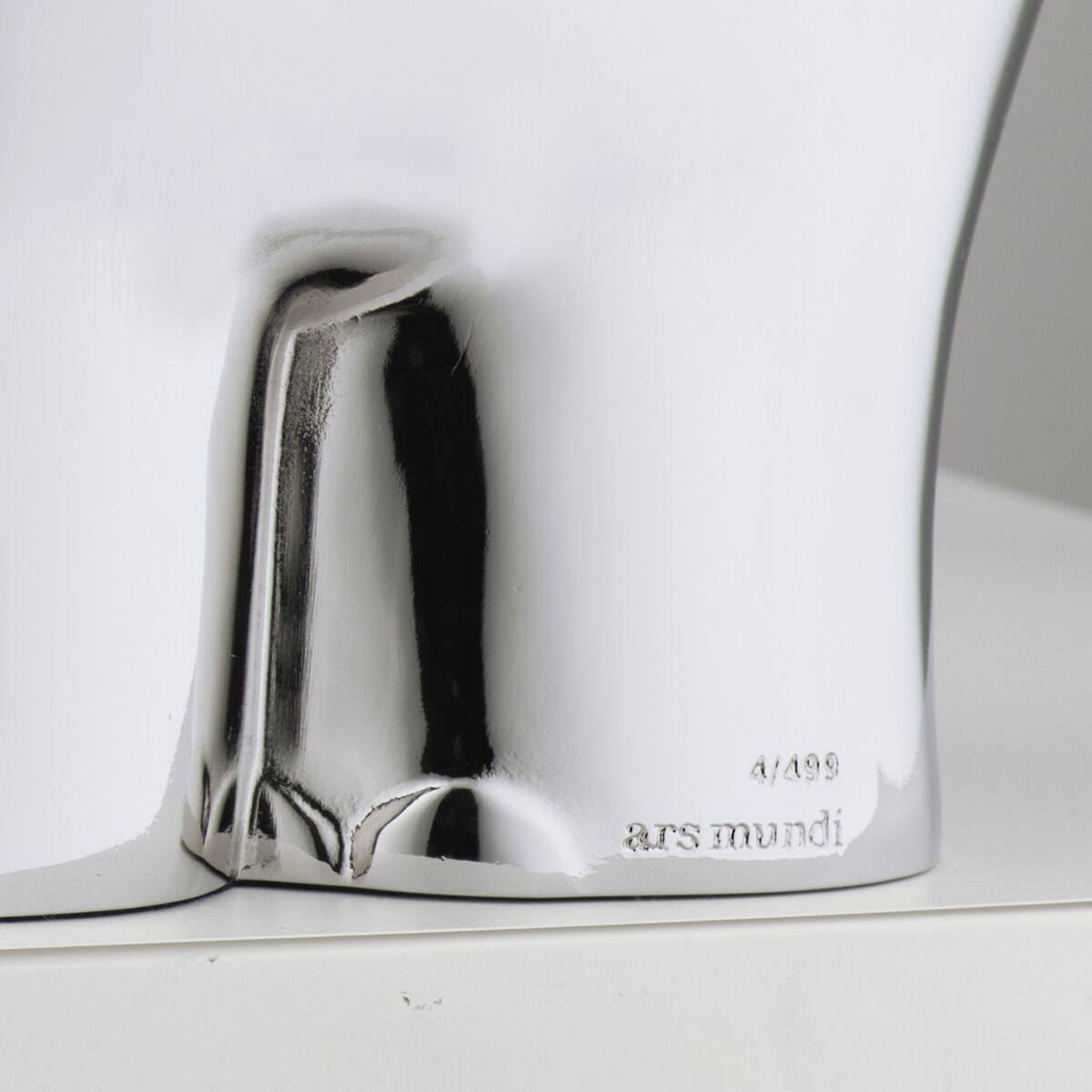 Detailansicht einer glänzenden, metallic-silbernen Kunstguss-Skulptur des Ottifanten von Otto Waalkes, aus der limitierten Edition von ars mundi, Nummerierung und Herstellerprägung sichtbar, auf einer weißen Oberfläche stehend.