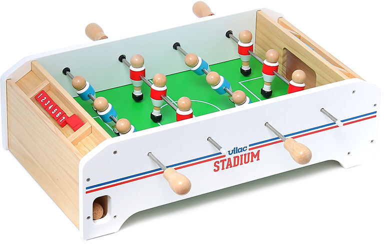 Ein Tischfußballspiel aus Holz mit grüner Spielfläche und Spielfiguren in roten und schwarzen Trikots auf weißem Hintergrund. Das Produkt heißt 'Tisch-Fußball'.
