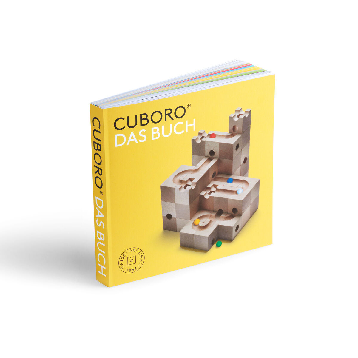 Ein CUBORO Set 'STANDARD 50 & DAS BUCH'. Das Buch hat ein gelbes Cover und zeigt eine Holzkugelbahn mit verschiedenen Murmelbahnelementen.