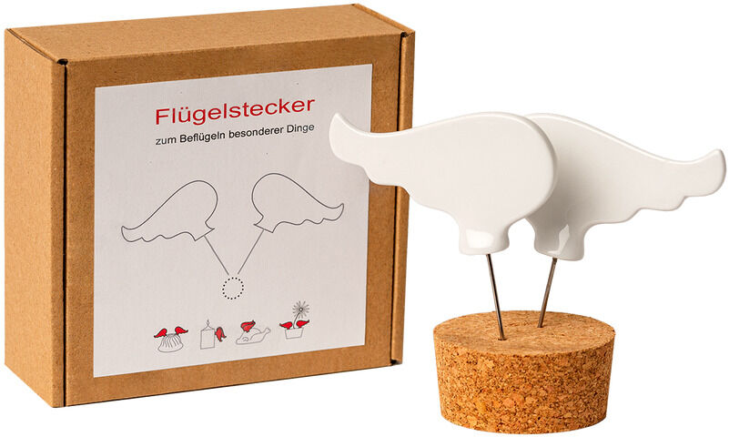 Ein Flügelstecker aus Porzellan mit einer weißen Flügelform und einer Korkbasis, präsentiert vor einer braunen Verpackungskiste.