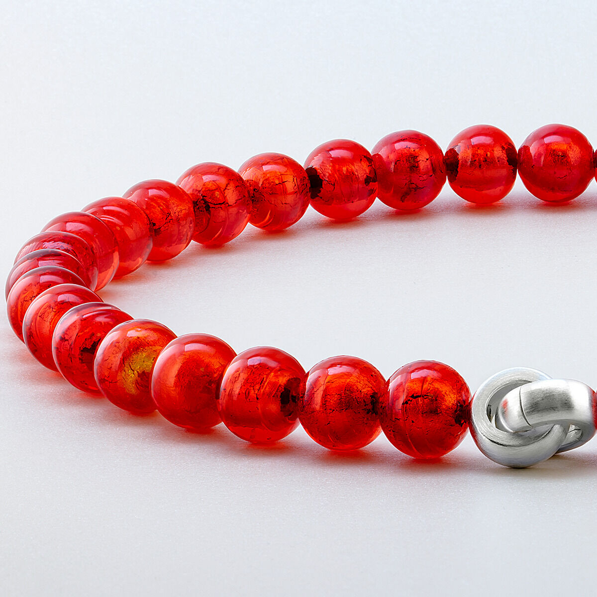 Das Bild zeigt das Collier »Hellrot« Murano von Menard. Es besteht aus leuchtend hellroten, glänzenden Muranoglas-Perlen mit einem Durchmesser von 12 mm. Die glänzende Schmuckschließe aus Metall wirkt elegant und modern. Der Hintergrund ist hell und neutral.