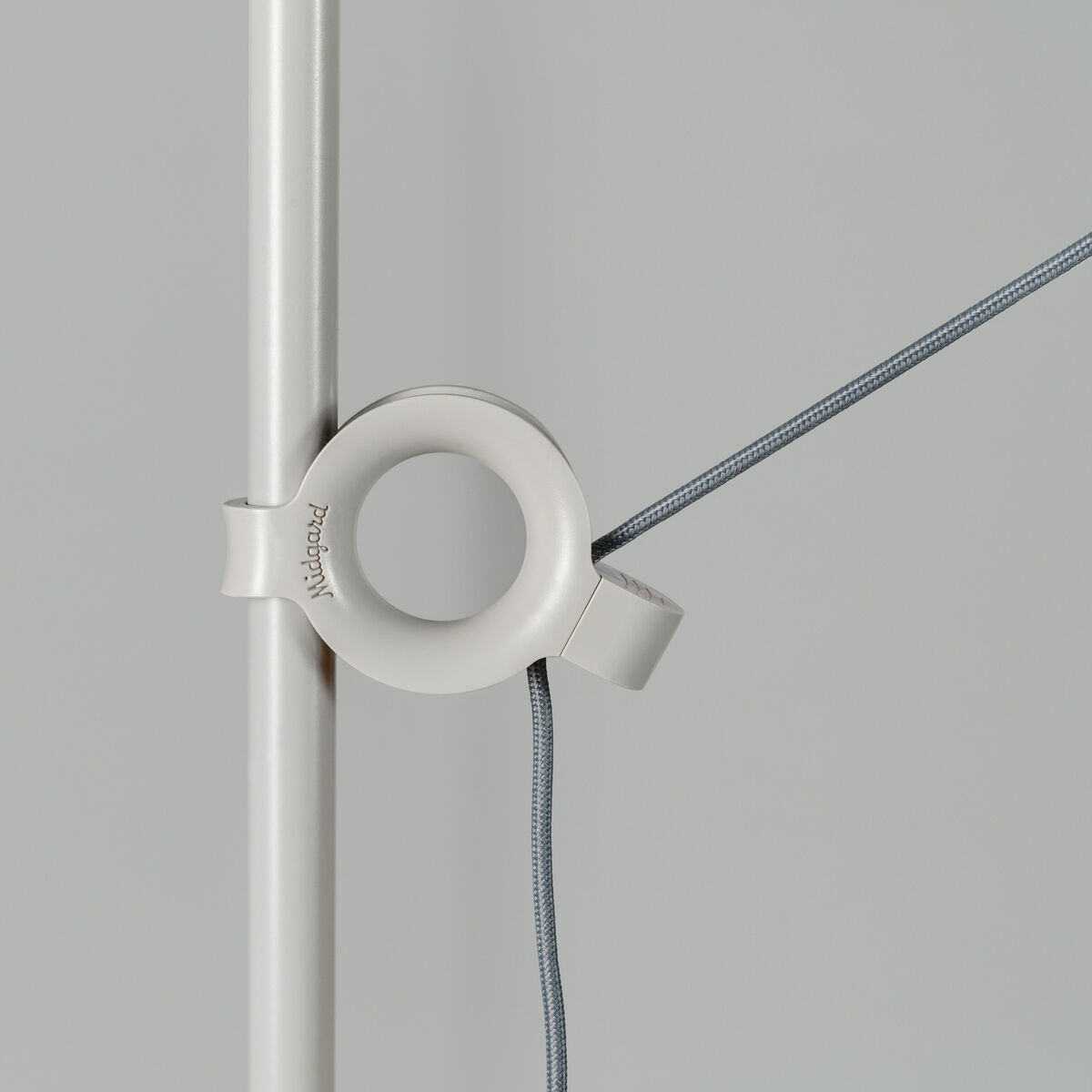 Detailansicht der Stehlampe AYNO Silk mit weißem Gestell und grauem Kabel.