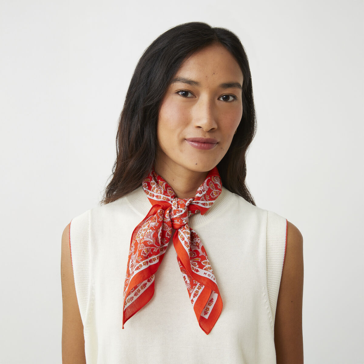 Das Baumwolltuch »No. 764« von MOISMONT ist quadratisch, aus feiner, leichter Baumwolle gefertigt und misst 65 x 65 cm. Es zeigt ein filigranes Paisley-Muster mit floralem Touch in Creme, Blau, Rot und Grün und besitzt einen schmalen, dekorativen Rand mit MOISMONT-Schriftzug.