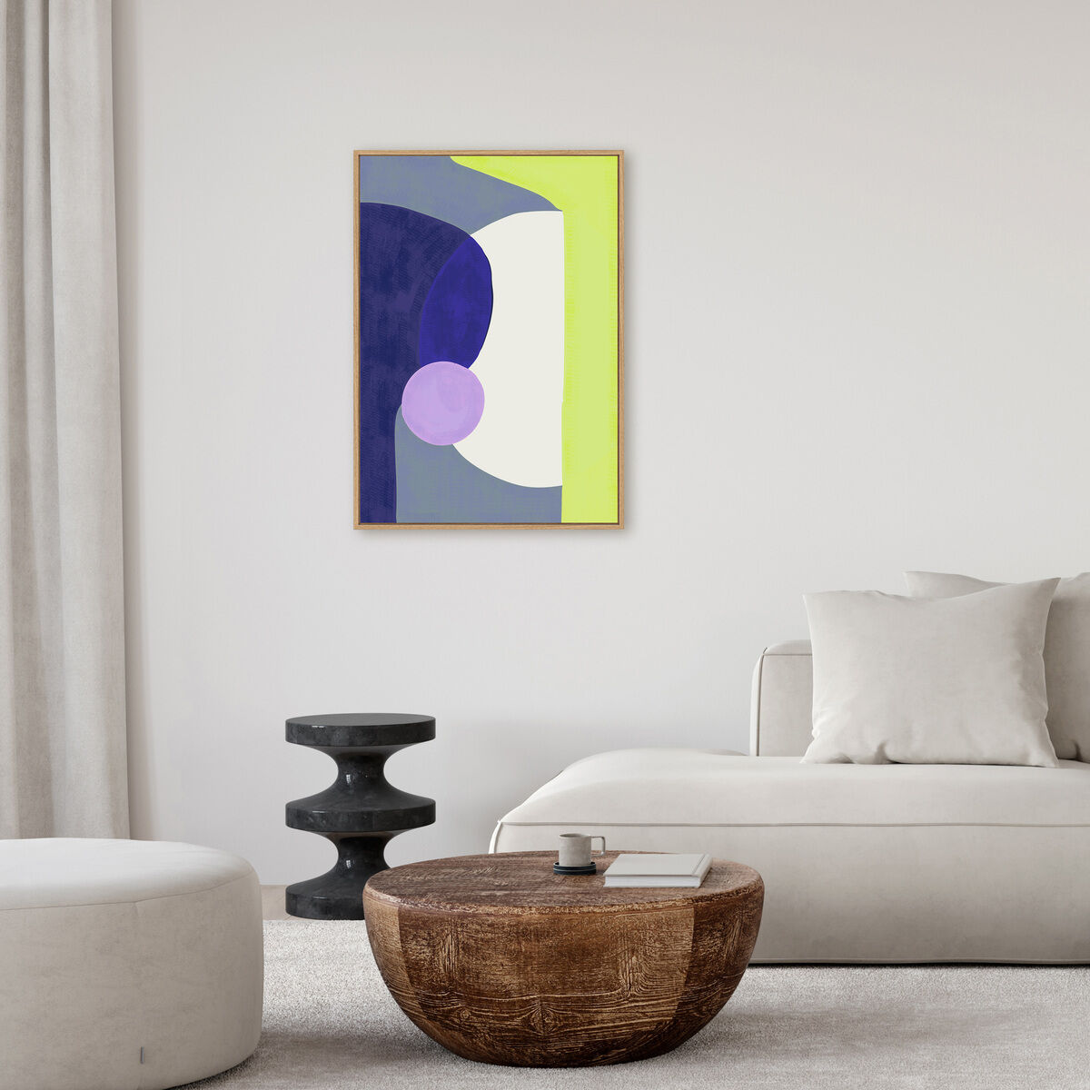 Abstraktes Leinwandbild in geometrischen Formen mit dominierenden Farben Blau, Weiß, Lila und Gelb, aufgehängt in einem modern eingerichteten Wohnzimmer mit beigen Möbeln, einem runden Hocker, einem Couchtisch aus Holz und neutraler Wanddekoration.