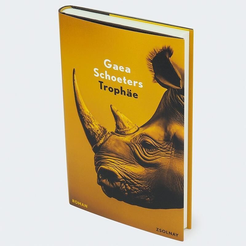 Ein Buch mit dem Titel ‚Gaea Schoeters: Trophäe‘. Das Buchcover ist in Orangetönen gehalten und zeigt die Abbildung eines Rhinozeroshornes.
