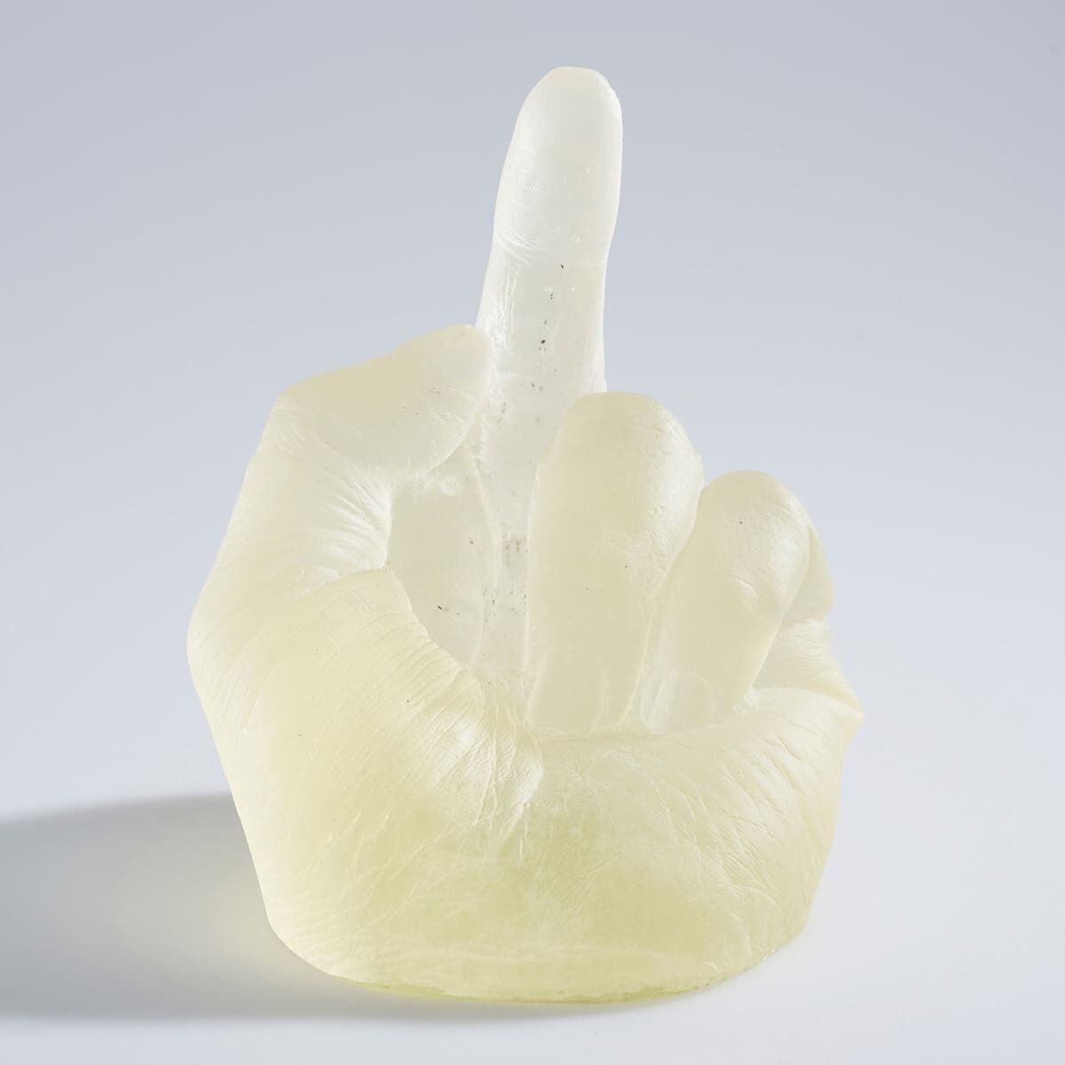 Eine transparente Skulptur einer erhobenen Hand aus Glas, die den mittleren Finger zeigt, geschaffen von Ai Weiwei. Die Skulptur hat eine helle, fast durchsichtige Beschaffenheit vor einem grauen Hintergrund.