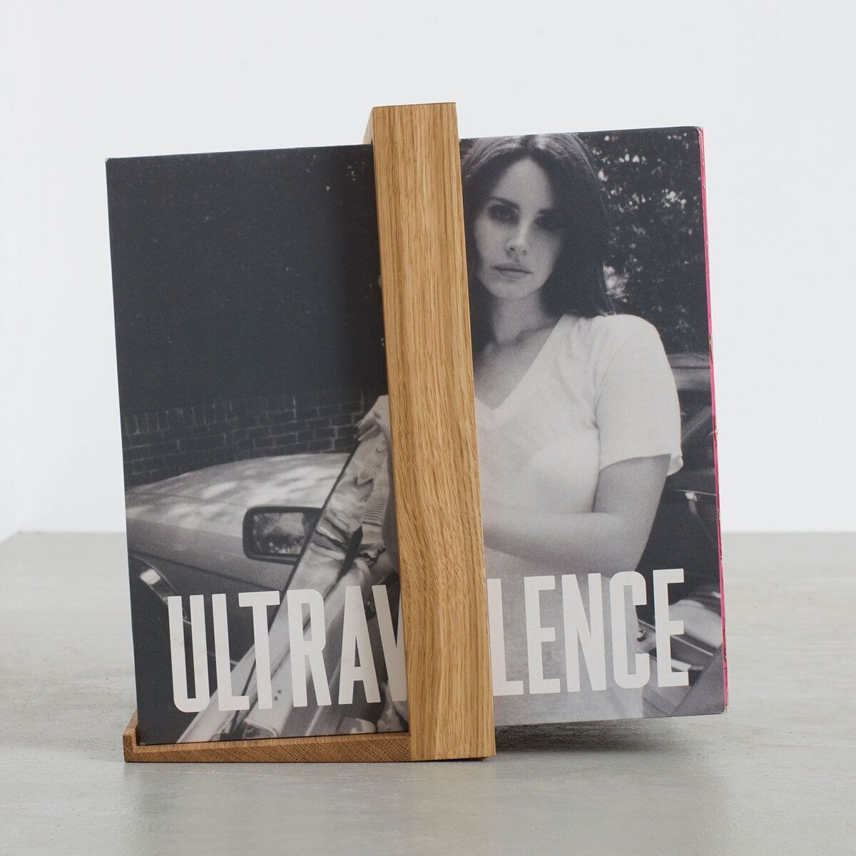 Ein Plattenständer aus Holz mit dem Namen »B-Seite«. Er hält eine Schallplatte in Schwarz-Weiß mit der Aufschrift ULTRAVIOLENCE. Der Hintergrund ist einfarbig Grau.