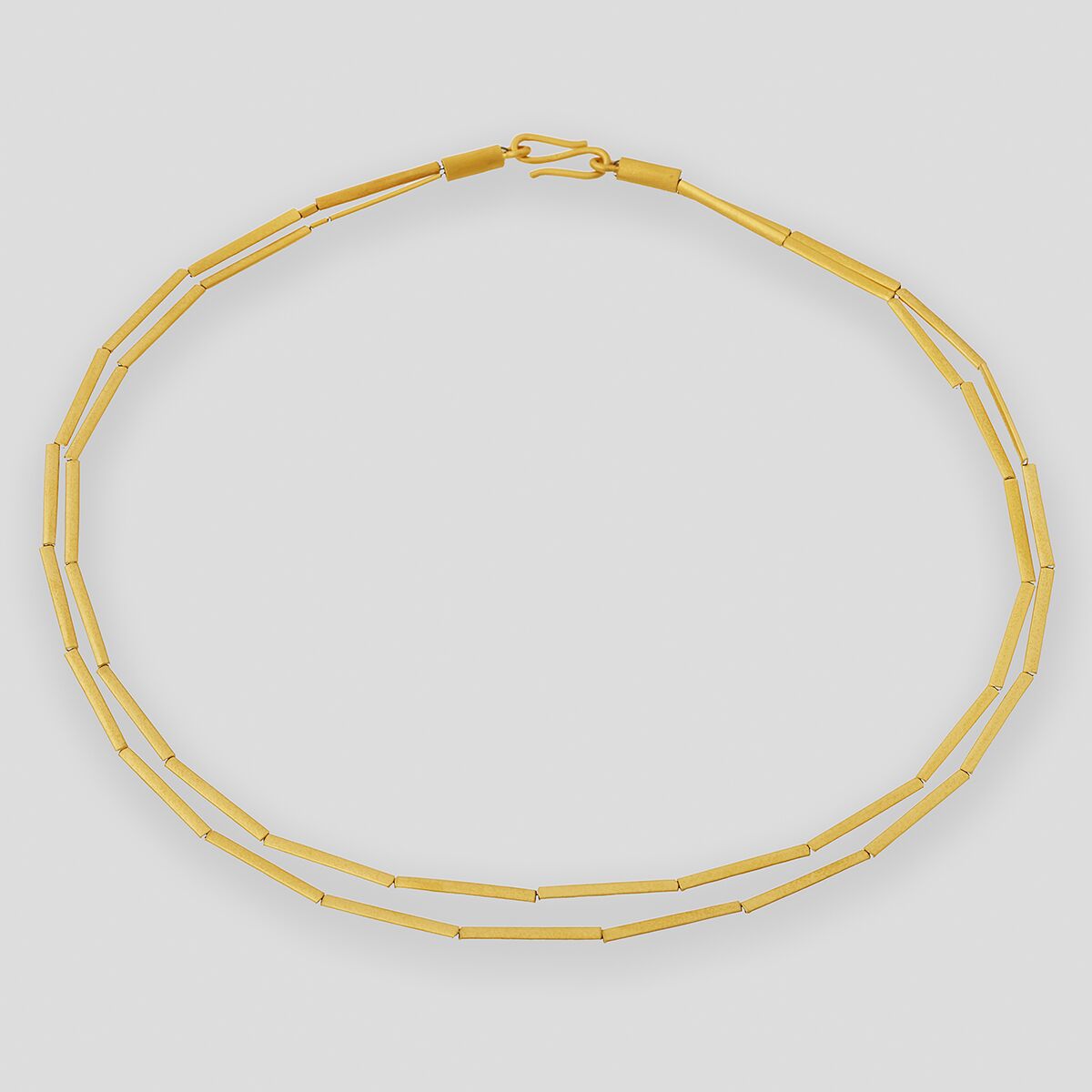 Zarte Halmkette aus feingoldplattiertem Silber mit elegantem, minimalistischem Design auf neutralem Hintergrund, ideal als stilvolles Schmuckstück für besondere Anlässe oder den Alltag.