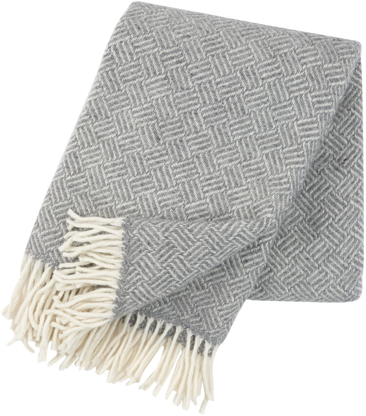 Hellgraue Decke »Samba« mit weißem Fransenabschluss und geometrischem Muster, bestehend aus Baumwollmaterial.