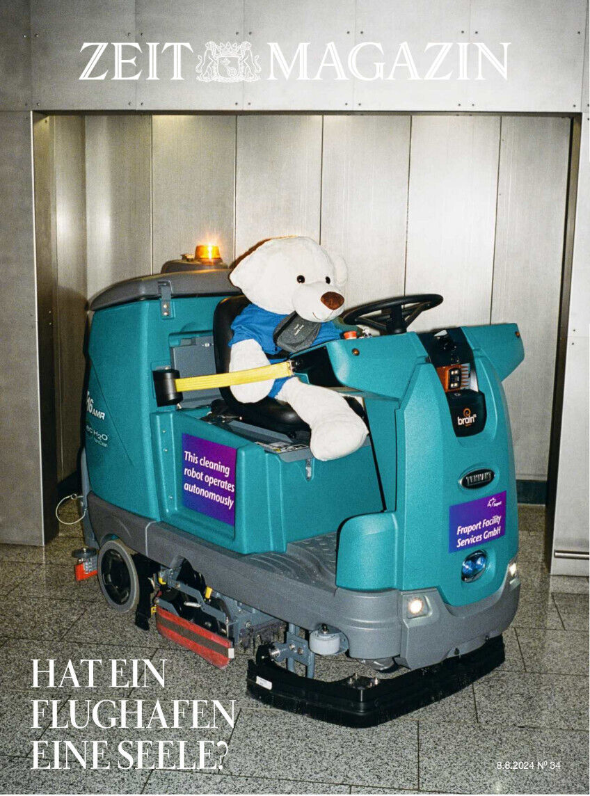 Das Cover der 34. Ausgabe von DIE ZEIT 2024 zeigt eine humorvolle Illustration: Ein Plüschtierhund fährt eine Reinigungsmaschine in einem grauen, industriellen Raum. Über dem Bild ist der Schriftzug 'ZEIT MAGAZIN' und unter dem Bild steht der Text 'HAT EIN FLUGHAFEN EINE SEELE?'.