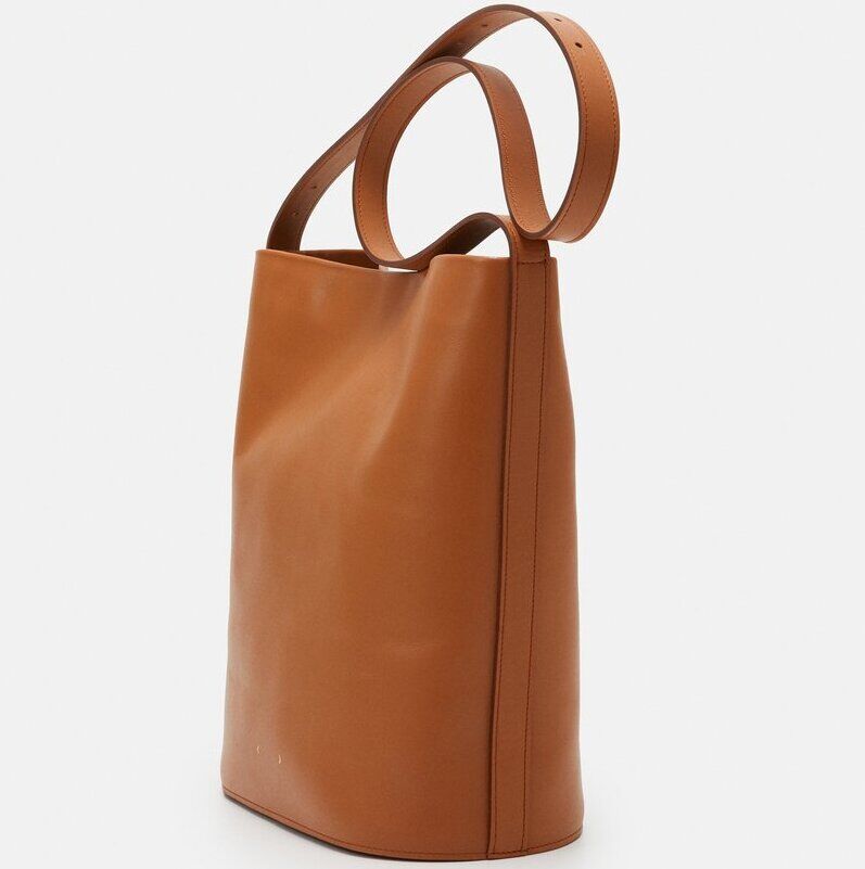 Braune Leder-Schultertasche mit schlichtem, minimalistischem Design und einem breiten Riemen.