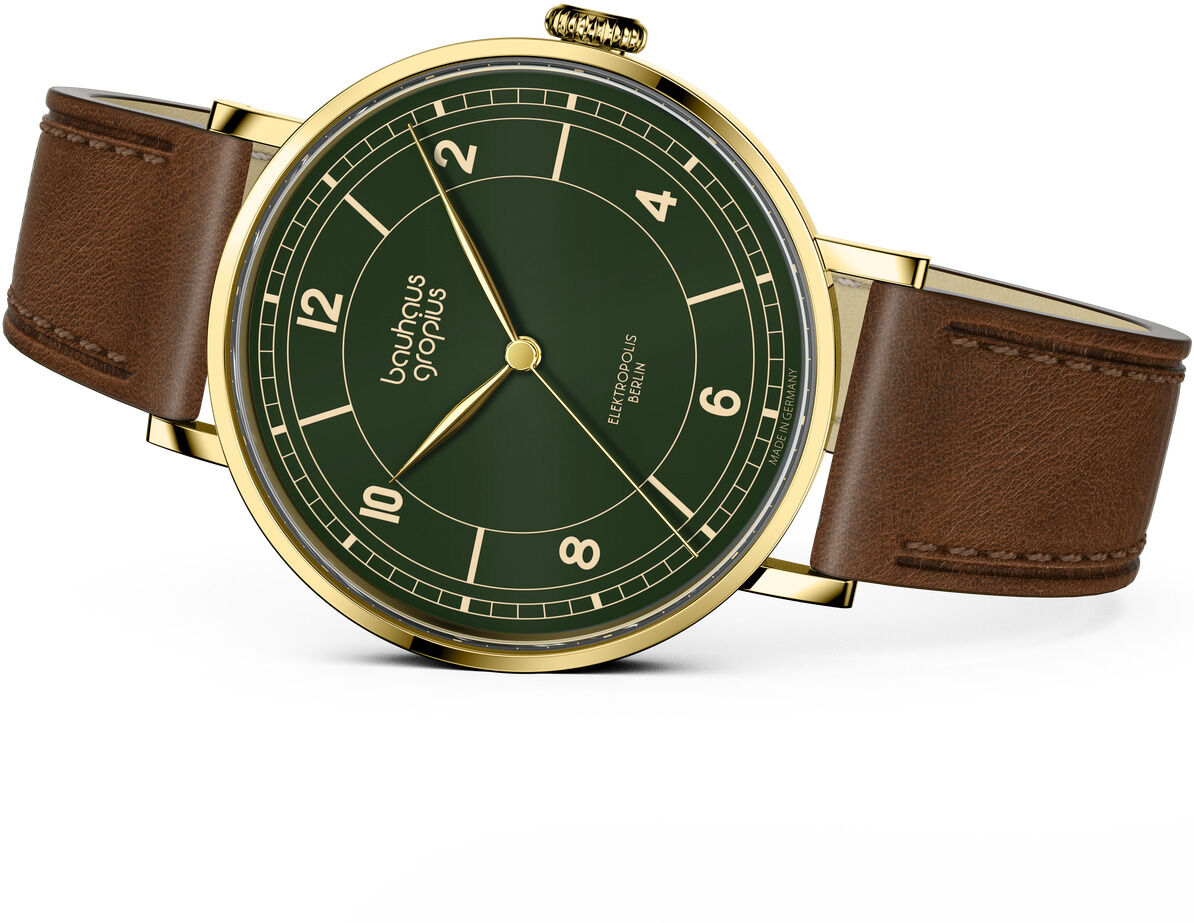 Abgebildet ist die ZEIT-Sonderedition Uhr »Elektropolis« Oliv der Marke Walter Gropius mit olivgrünem Zifferblatt, goldfarbenem Edelstahlgehäuse und braunem Lederarmband. Die Uhr hat schlanke Zeiger, arabische Ziffern und ein elegantes, minimalistisches Design.