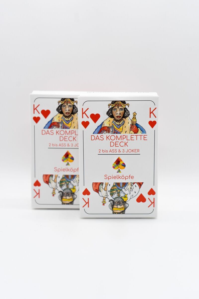 Zwei Packungen Rommé-Spielkarten mit dem Titel 'Das komplette Deck' auf weißem Hintergrund. Die Verpackung zeigt eine König-Karte in Rot auf der Vorderseite und ist hauptsächlich in den Farben Weiß und Rot gehalten.