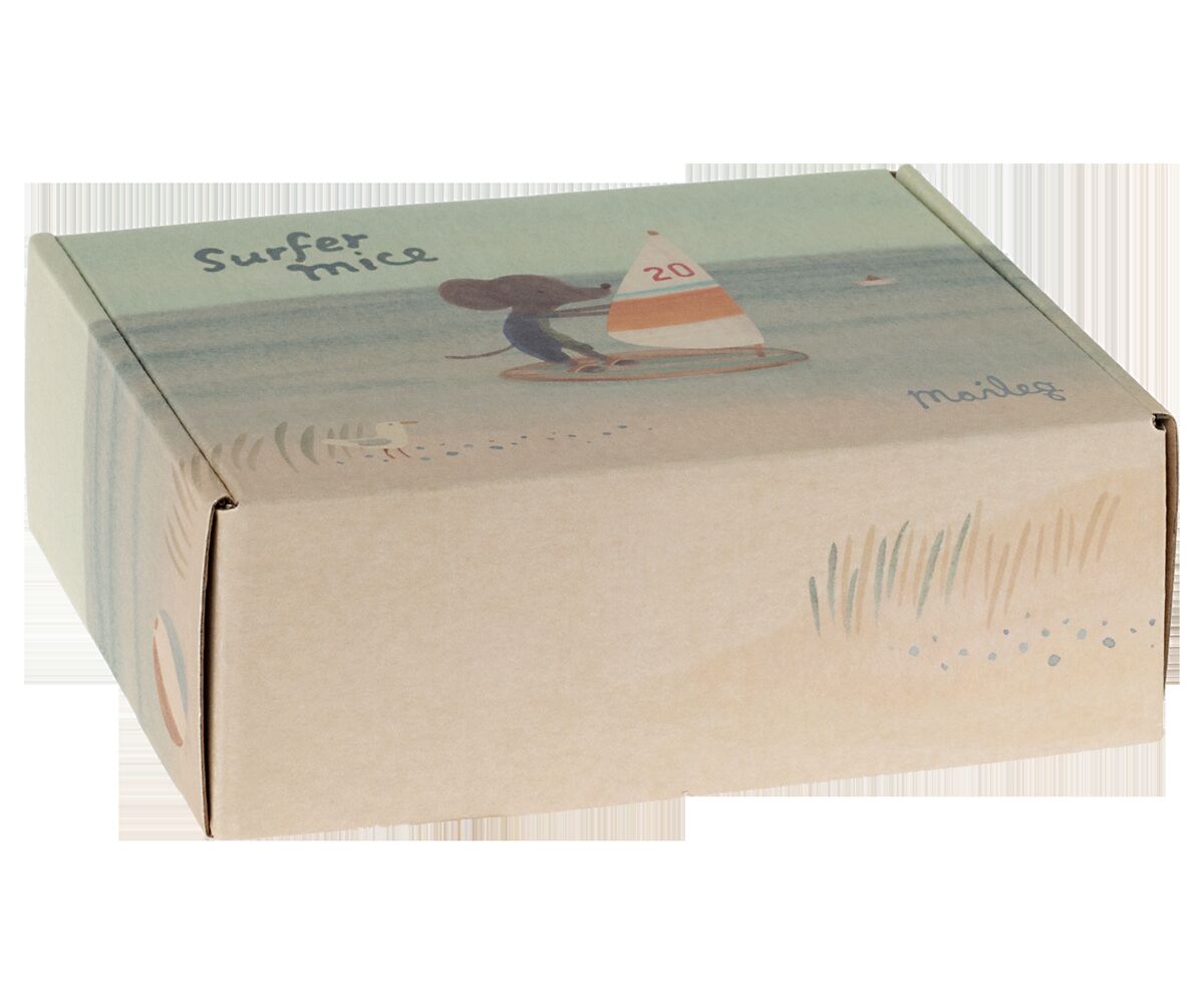 Verpackungsbox mit der Aufschrift 'Surfer mice', illustriert mit einer Maus auf einem Surfbrett mit einem Segelboot im Hintergrund. Natürliche und sommerliche Farbtöne.
