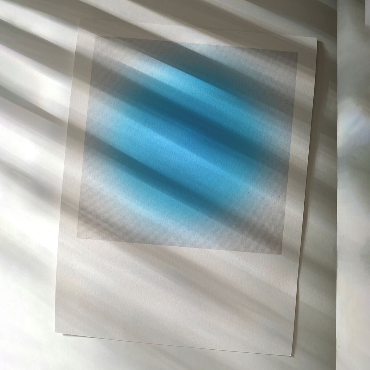Das Bild zeigt den Fine-Art-Print ZEIT-Sonderedition »Sorbet« von Studio Anastasia Benko. In der Mitte befindet sich ein großes Quadrat mit sanften türkis- und blauen Farbverläufen auf weißem Hintergrund. Durch Lichteinfall entstehen weiche Schatten auf der strukturierten Papieroberfläche.