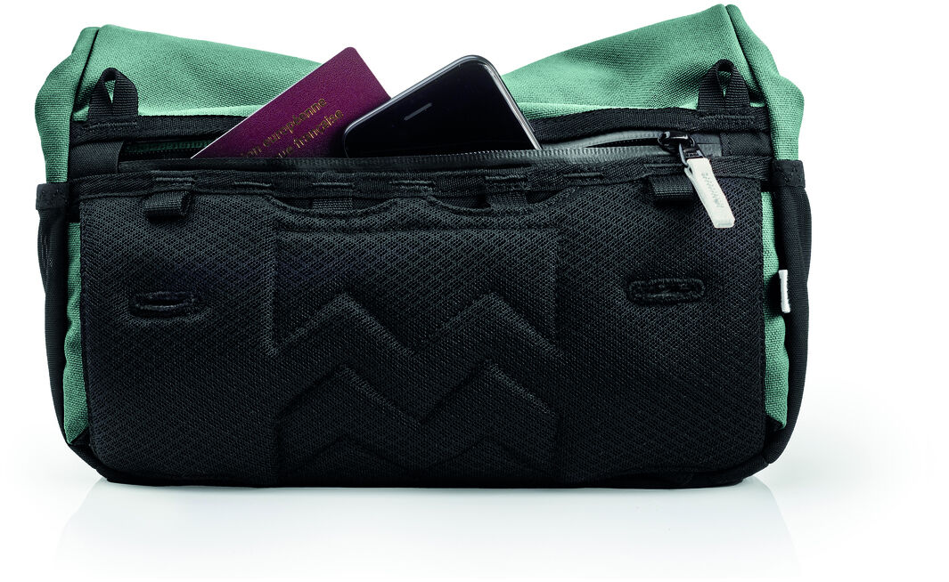 Lenkertasche »Piha« in grün und schwarz. Die Tasche ist mit einem Reißverschluss versehen und zeigt teilweise geöffnet einen Blick auf den Inhalt, darunter ein Pass und ein Smartphone. Praktische Fahrradtasche für Outdoor-Aktivitäten.