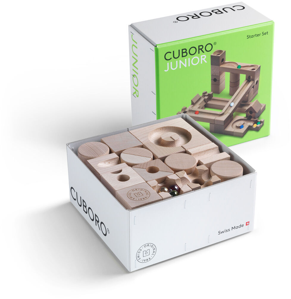 Kugelbahn Starter-Set »JUNIOR« bestehend aus Holzbausteinen in einem weißen Karton mit grüner Verpackung. Die Bausteine sind naturbelassen und zeigen verschiedene Formen und Löcher, um eine Kugelbahn zu bauen.