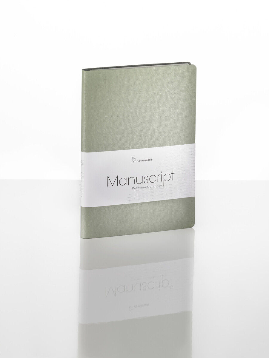 Ein grünes Notizbuch im DIN-A5-Format mit der Aufschrift »Manuscript« auf einer weißen Banderole liegt auf einer glänzenden Oberfläche.
