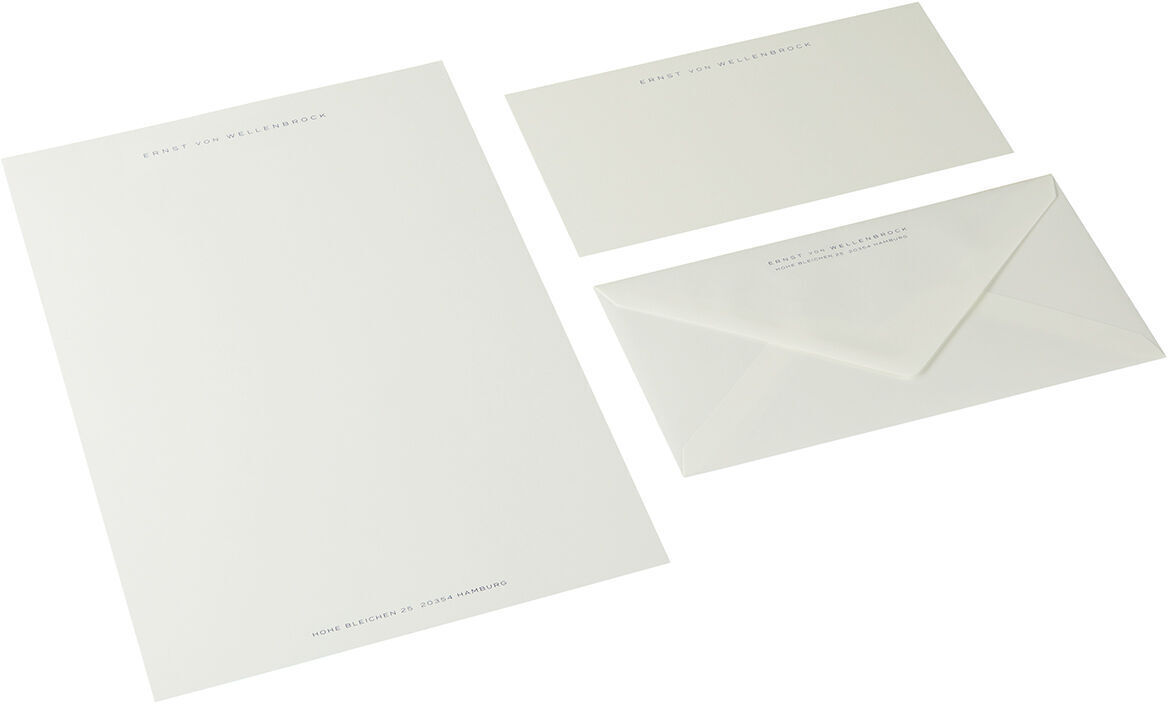 Ein Set aus A4-Briefpapier in Dunkelblau mit passendem Umschlag und kleinerer Karte, jeweils mit feiner Beschriftung in Weiß. Das Papier wirkt hochwertig und eignet sich ideal für geschäftliche Korrespondenz.