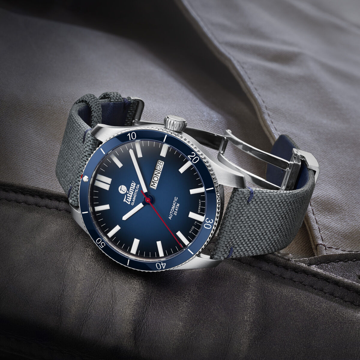 ZEIT-Sonderedition Grand Flieger Airport Automatic. Luxusuhr mit blauem Zifferblatt, silbernem Gehäuse und grauem Armband. Ideal für Männer als stilvolles Accessoire.