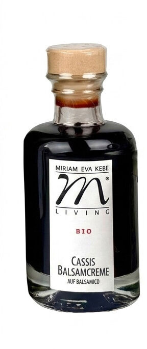 Glasflasche mit Korkverschluss, enthält dunkelrote Cassis Balsamcreme von Kebe Living. Das Etikett zeigt Marke, Bio-Hinweis, Produktname und Herkunft. Klare Flüssigkeit, modernes, minimalistisches Design, ideal als Gourmet-Zutat für Salate.