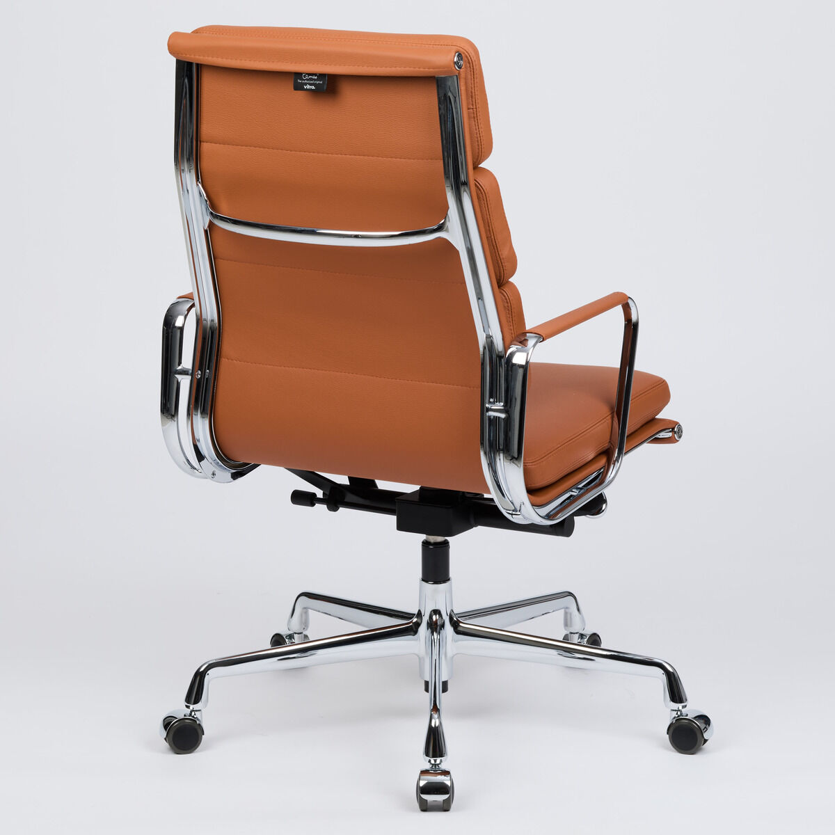 Hochwertiger Schreibtischstuhl der ZEIT-Sonderedition »Vitra Soft Pad EA219« in cognacfarbenem Leder, Rückansicht. Elegante, gepolsterte Sitz- und Rückenelemente, vollflächig lederbezogen. Fünfstern-Untergestell aus glänzendem Chrom, gebremste Rollen, moderne Linienführung.