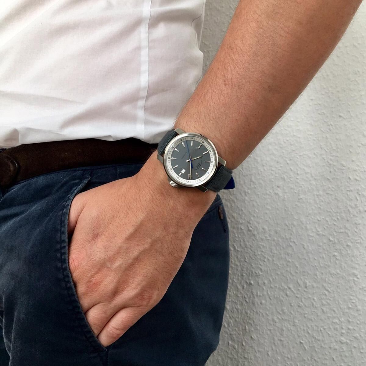 Eine Person trägt am Handgelenk die ZEIT-Sonderedition »29er Big« Armbanduhr von Mühle-Glashütte (2019), mit einem silbernen Gehäuse und einem schwarzen Lederarmband.