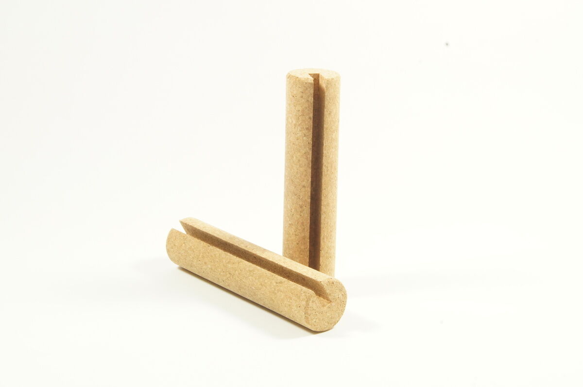 Zwei zylindrische Holzrollen stehen aufrecht auf einer glatten, hellen Oberfläche. Diese bilden Zubehör zu einem Balance Board, das Gleichgewichtstraining unterstützt.