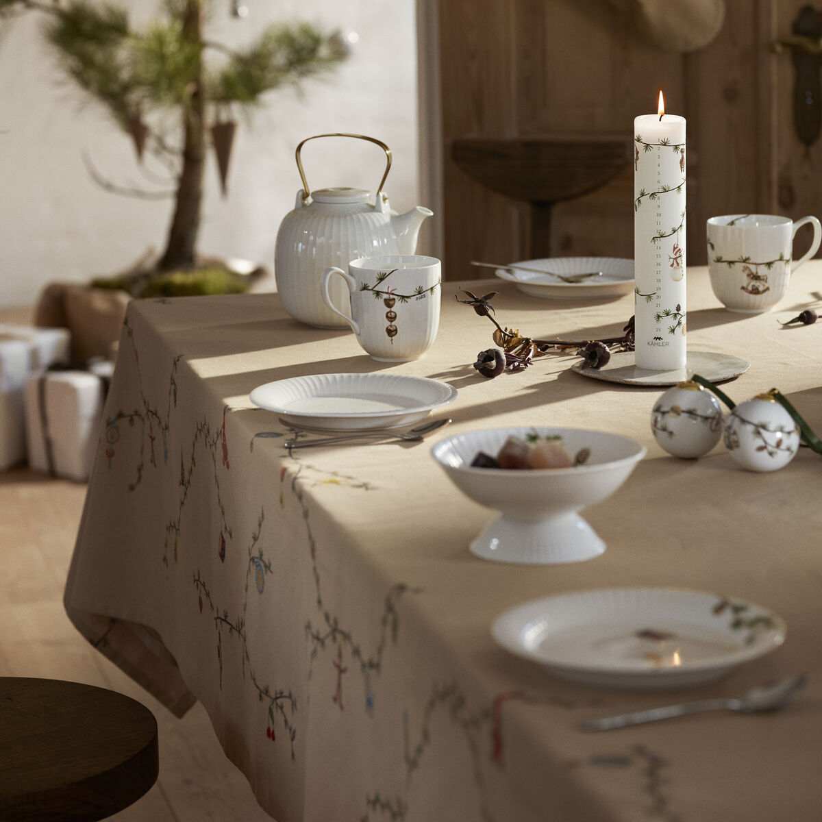 Beigefarbene Tischdecke der Serie Hammershøi auf einem festlich gedeckten Tisch, weihnachtlich dekoriert mit Kerzen, Porzellan und Tannenzweigen in einem skandinavischen Esszimmer.