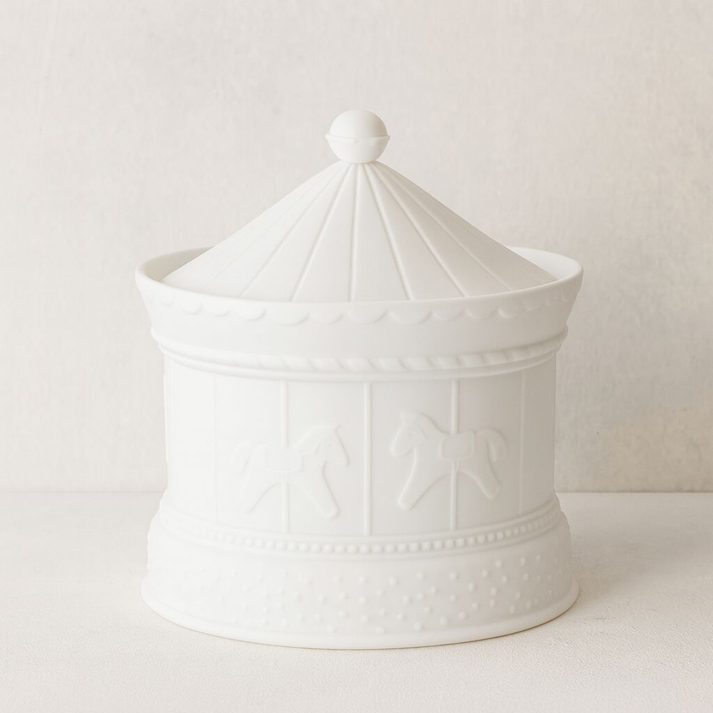 Weiße Porzellandose in Form eines nostalgischen Karussells mit Pferdemotiven und fein gearbeiteten Details. Die Dose steht auf einer hellen Oberfläche und eignet sich als dekoratives Wohnaccessoire oder Geschenk, besonders für Kinderzimmer und festliche Anlässe.