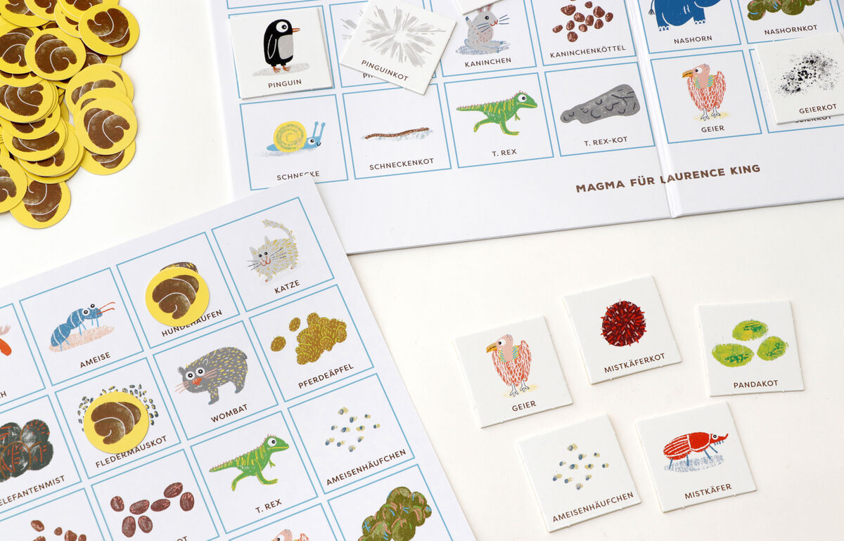 Das Bild zeigt das Bingo-Spiel '»Tierkacke Bingo«' mit Spielkarten und Jetons, die verschiedene Tiere und deren Kot darstellen. Das Spiel beinhaltet Karten mit Illustrationen von Tieren wie Pinguinen, Elefanten, Eidechsen und Koalas.