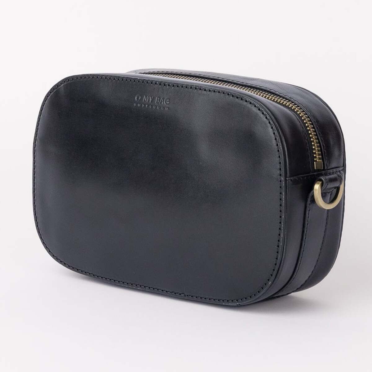Schlichte Umhängetasche »Maya« in schwarzer Lederoptik mit rundem, kompaktem Design und goldfarbenem Reißverschluss, auf hellem Hintergrund stehend.
