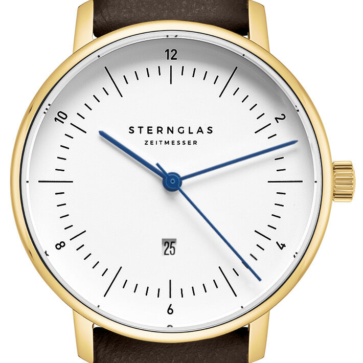 Die Abbildung zeigt eine elegante Armbanduhr der ZEIT-Sonderedition »Naos Xs« von Sternglas mit weißem Zifferblatt, goldfarbenem Gehäuse, blauen Zeigern und schwarzem Lederarmband. Die Uhr verfügt über eine Datumsanzeige auf sechs Uhr und ein minimalistisches, modernes Design.