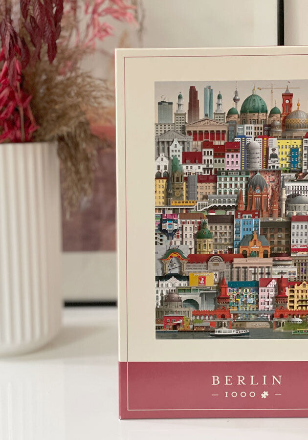 Puzzle mit 1000 Teilen, das die Sehenswürdigkeiten von Berlin darstellt. Bunter Karton mit Abbildung von Berliner Wahrzeichen wie dem Brandenburger Tor und dem Fernsehturm mit vielfältigen Details.