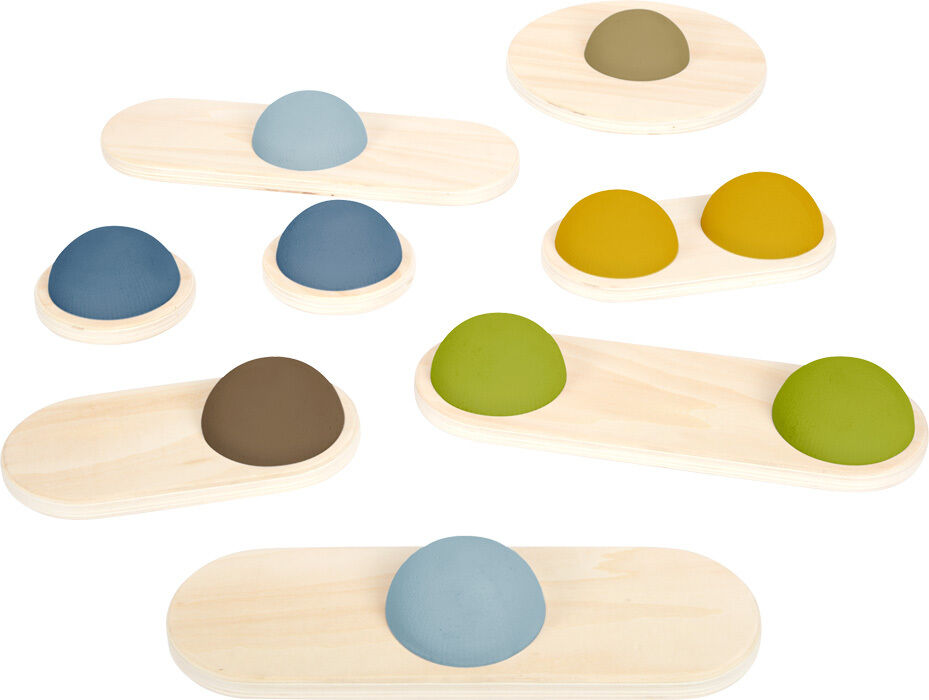 Mehrere Balanciersteine aus Holz mit farbigen Halbkugeln in Blau, Gelb, Grün und Braun auf einer hellen Holzplatte angeordnet. Die Farben sind weich und naturverbunden. Das Spielzeug ist darauf ausgelegt, Kinder in ihrem Gleichgewicht und ihrer Motorik zu fördern.