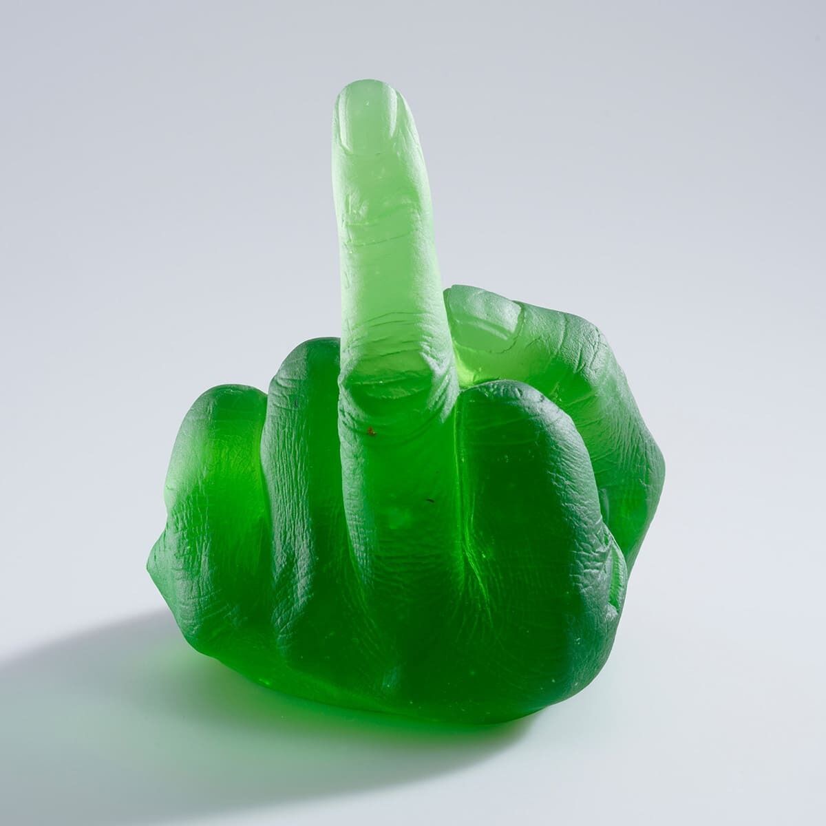 Eine gläserne Skulptur von Ai Weiwei, die grün ist und eine Hand darstellt, bei der der Mittelfinger ausgestreckt ist. Die Skulptur hat eine moderne, provokative Erscheinung.